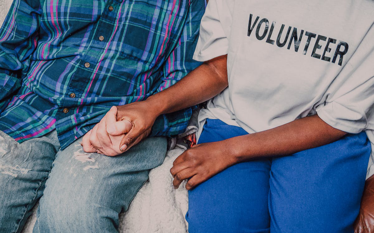 Cropped photo of a person holding hand of a disadvantaged individual; demonstrating community support